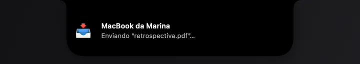 Card do AirDrop no notch mostrando um envio em andamento para outro Mac